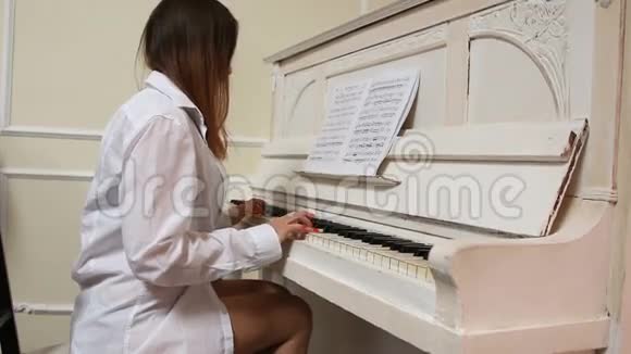 穿着内衣和男衬衫的女孩弹钢琴视频的预览图