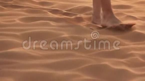 戴着围巾在沙漠沙丘上散步的女孩视频的预览图