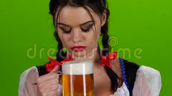 嬉戏的女孩吹着一杯啤酒微笑着绿色屏幕视频的预览图