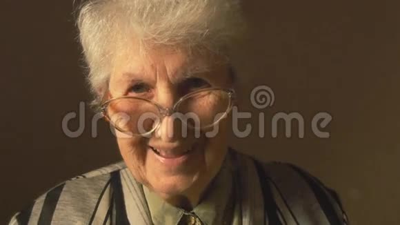 老太婆带着眼镜看着镜头笑了视频的预览图