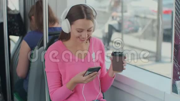 一位年轻女性乘客在公共交通工具上享受旅行的肖像戴着耳机坐在现代电车上视频的预览图
