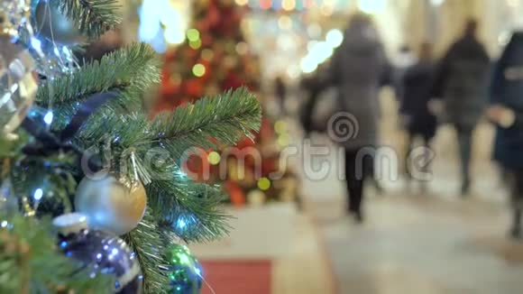 商场里喜庆的气氛在前景的圣诞杉不在焦点的人走路和买礼物视频的预览图
