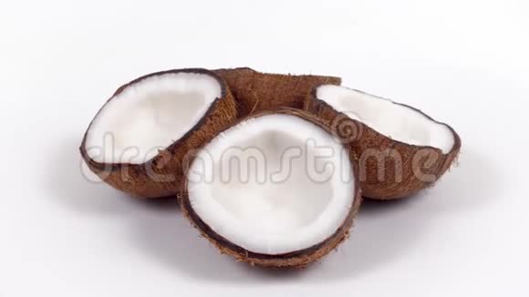 四个成熟的椰子半部分美味的果肉旋转在白色孤立的背景可循环无缝视频的预览图