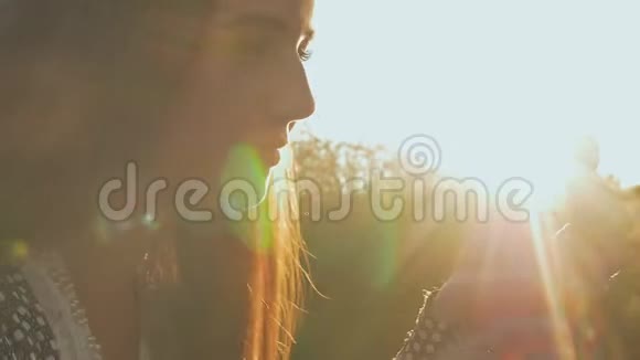 年轻的女孩在傍晚的阳光下抱着一个黑色的坐立不安的旋转者在户外视频的预览图