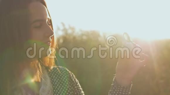 年轻的女孩在傍晚的阳光下抱着一个白色和黑色的坐立不安的旋转者在户外视频的预览图