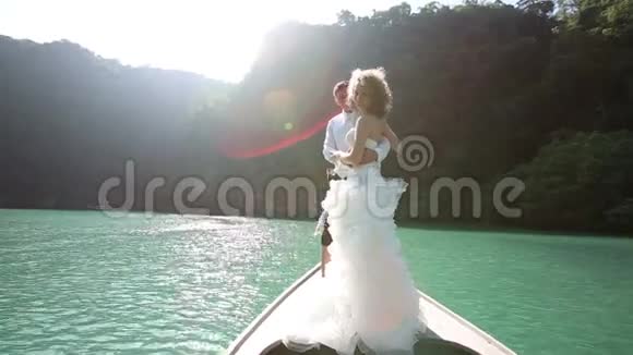 新婚夫妇站在长尾船上视频的预览图