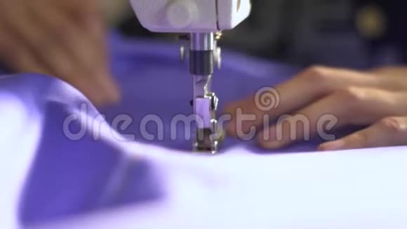 女裁缝把紫色布缝在缝纫机上动作缓慢视频的预览图