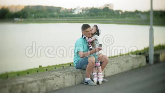 父亲和女儿骑着溜冰鞋女孩学习溜冰摔倒父亲教女儿骑马视频的预览图