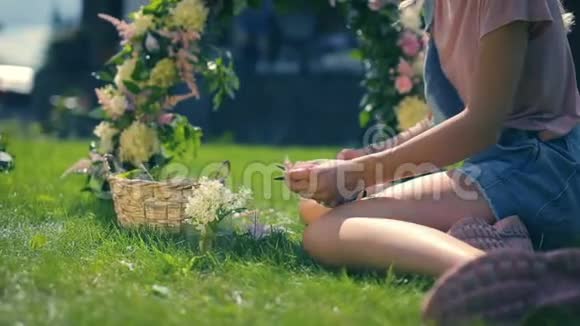 少女在绿草如茵阳光明媚的夏日花园里享受鲜花装饰视频的预览图