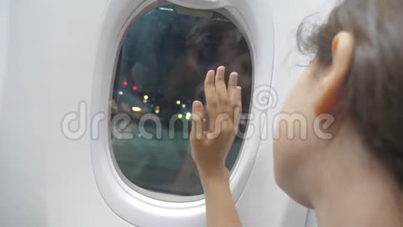 少女在飞机概念的窗口挥手告别他的生活方式年轻的女孩视频的预览图