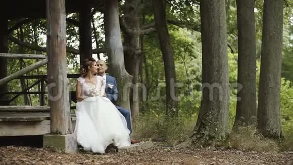 幸福的新娘和新郎在森林的房子里谈笑风生视频的预览图