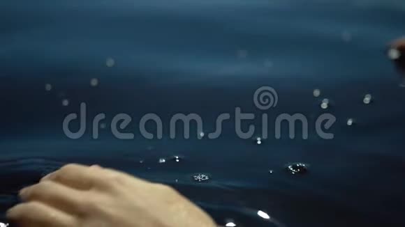女性的手在湖水中移动慢动作特写镜头视频的预览图