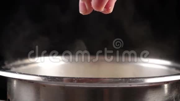 在金属锅中的沸水中加入盐慢动作视频的预览图