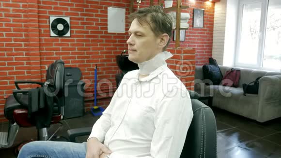 一个男人坐在理发店的扶手椅上准备理发视频的预览图