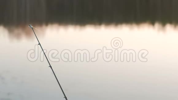 河岸上的钓鱼竿在春天的傍晚日落时钓鱼视频的预览图