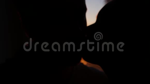 一对相爱的夫妇在美丽的黄色日落中一个女孩亲吻一个男人的脸颊4k3840x2160视频的预览图