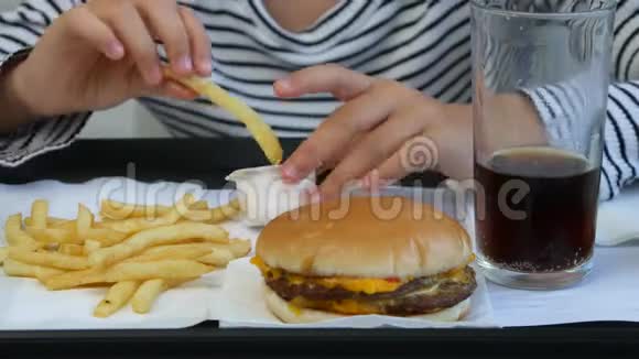 小孩吃快餐小孩在餐馆吃汉堡包小孩喝果汁视频的预览图