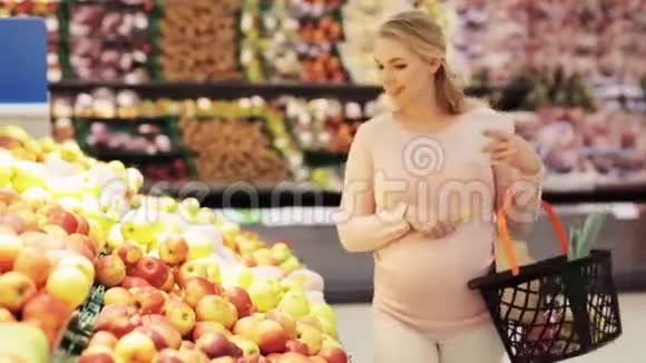 快乐孕妇在杂货店买苹果视频的预览图