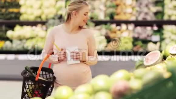 带篮子的孕妇在杂货店买梨视频的预览图