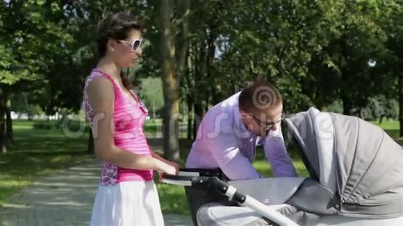 年轻的父母把孩子从婴儿车上带走视频的预览图