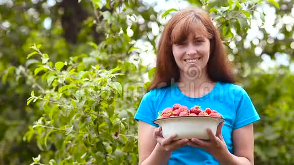 草莓红的熟的甜的拿着盘子一个小女孩微笑着含有维生素的膳食浆果视频的预览图