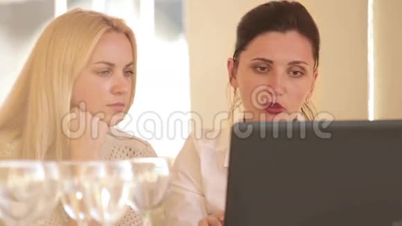 两位同事用笔记本电脑讨论她们的餐厅想法视频的预览图