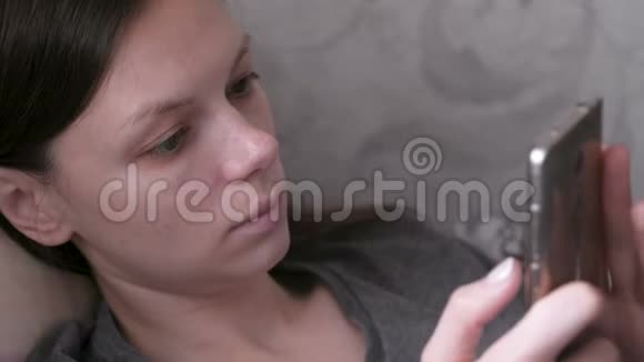 女人躺在沙发上用手机看东西闭上脸视频的预览图
