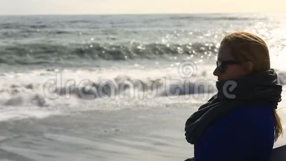 一个戴着太阳镜的女孩站在海滨看暴风雨视频的预览图