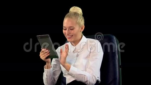带着平板电脑的年轻女人在椅子上笑阿尔法频道中东视频的预览图