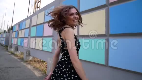一个穿着运动鞋和连衣裙的女孩在城里走来走去视频的预览图