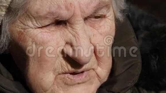 会说话的老太婆的肖像严肃的祖母坐在户外说话特写视频的预览图