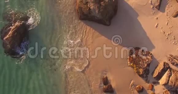 海滩高空拍摄在日落时海浪拍打沙石视频的预览图