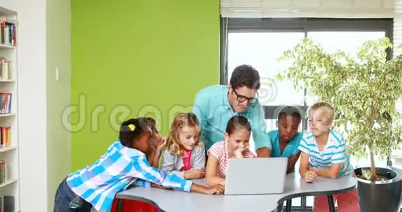 老师和孩子们在教室里用笔记本电脑视频的预览图