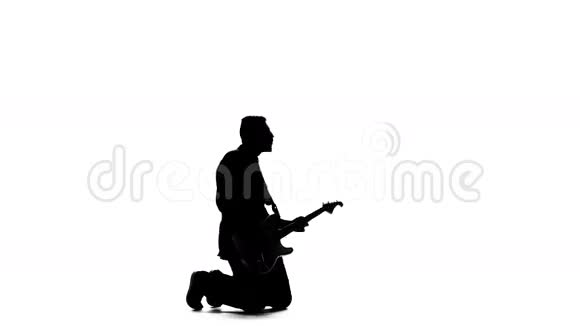 音乐家用电动低音吉他在他的膝盖上演奏剪影视频的预览图