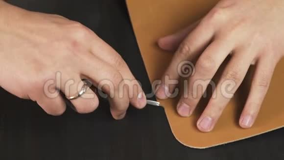 工匠他的手在桌子上用一块皮革工作视频的预览图