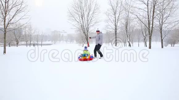 冬天在一个白雪覆盖的公园里孩子们和一只狗玩得很开心视频的预览图