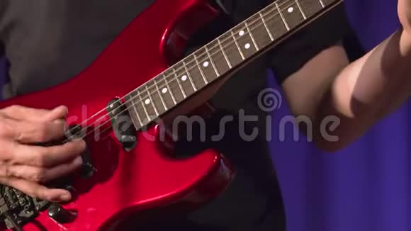 音乐家在舞台上演奏红色电吉他视频的预览图