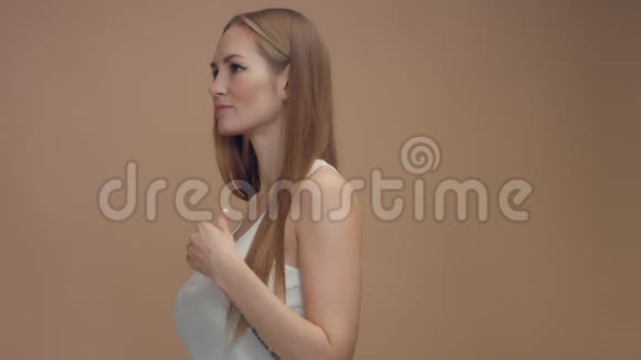 米色背景的摄影棚美女模特风吹头发视频的预览图