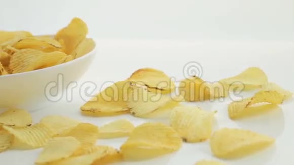 一个男人手里拿着碗里的薯片不健康的有害食物黄色美味的土豆肋条脆片随机躺着视频的预览图