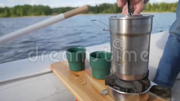 年轻人在充气船上准备茶高清慢镜头视频的预览图