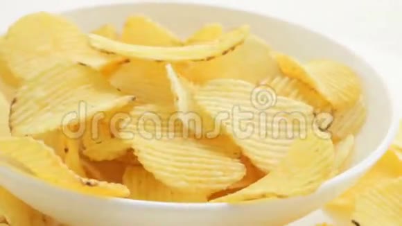 男人的手拿着碗里的薯片腐烂不健康的有害食物黄色美味的土豆肋脆薯片视频的预览图