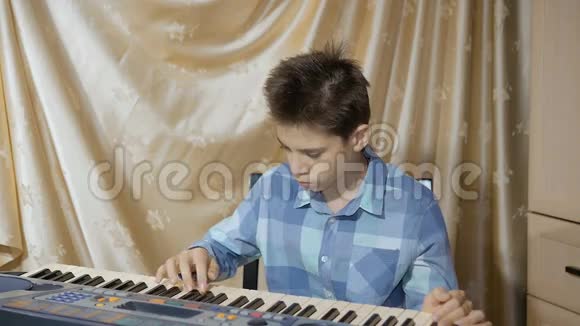 快乐少年在电子钢琴上演奏作曲视频的预览图