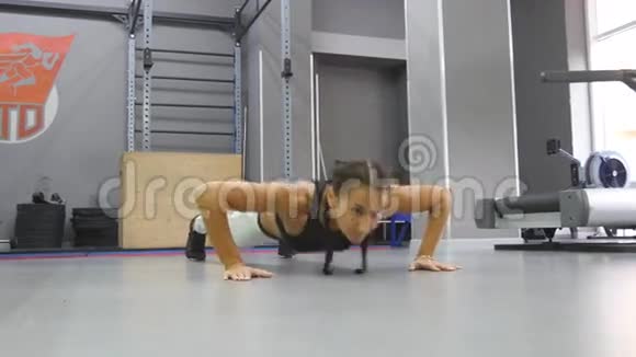 适合肌肉发达的女人在健身房做俯卧撑在希思俱乐部训练年轻的运动女孩女运动员视频的预览图
