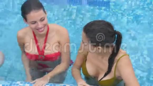 三个年轻的朋友在游泳池里谈笑风生视频的预览图