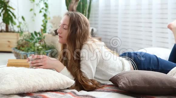 女人在卧室的床上喝咖啡看书视频的预览图