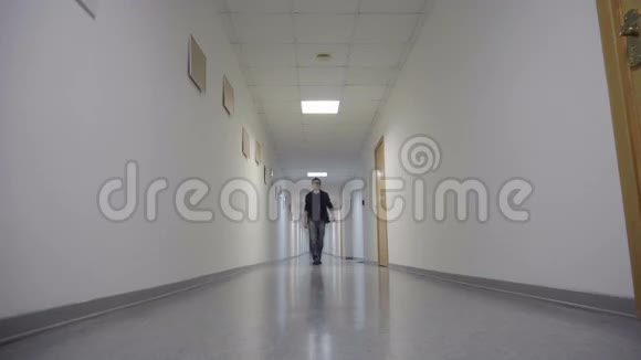 年轻人走在长长的白色走廊上视频的预览图