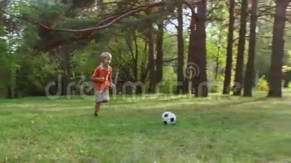 在户外踢美式足球的小男孩视频的预览图