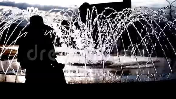 一个女人坐在喷泉边的剪影视频的预览图