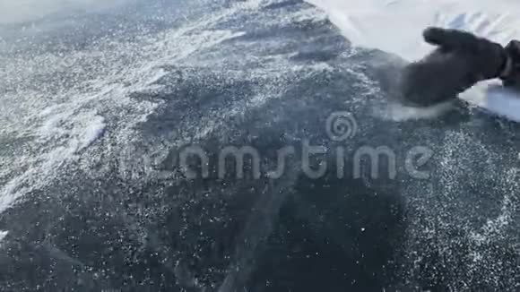 人在冰上撒雪慢动作雪粒美丽地散落在冰上手套里的人视频的预览图