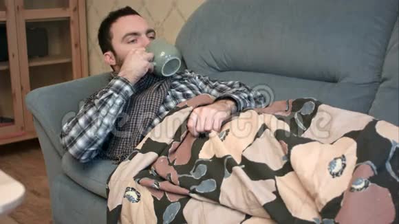 生病的年轻人在床上喝热茶或抗热药视频的预览图